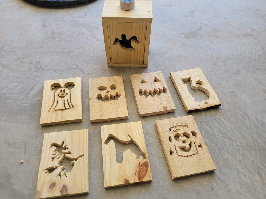Raw cedar Halloween face panels carved on the CNC and laid out before assembly