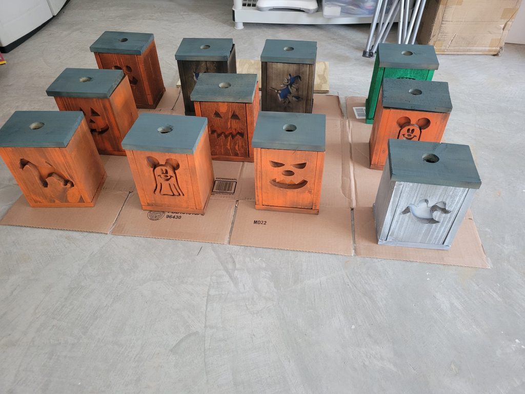 Painted and stained Halloween lantern boxes grouped together with lid holes ready for solar lights