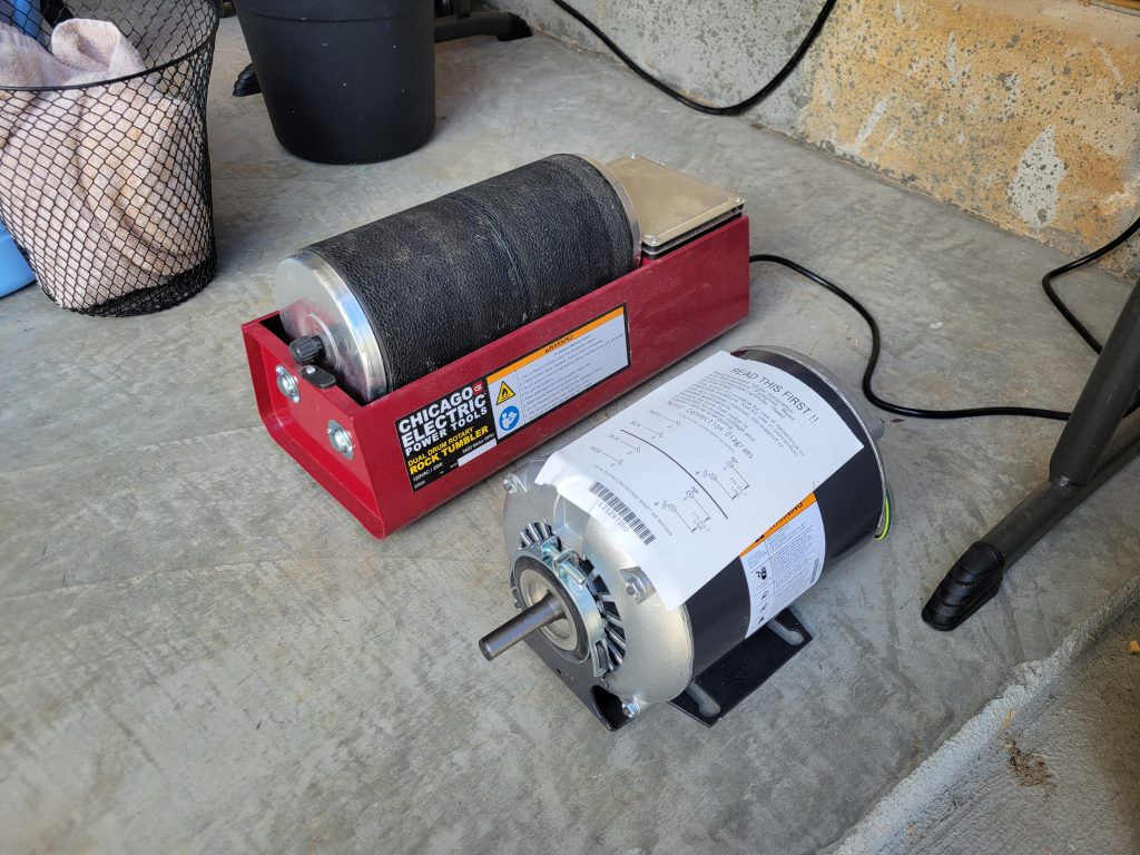 Harbor Freight rock tumbler sitting beside a larger Dayton motor before the custom rock tumbler build.