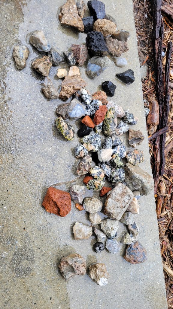 Rocks laid out on concrete before going into the custom rock tumbler.