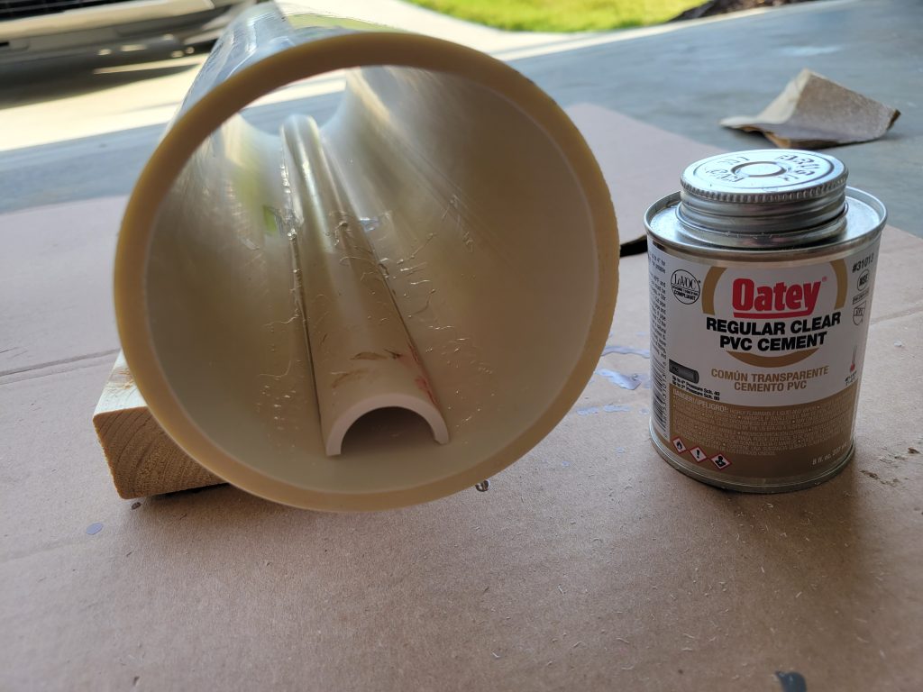Inside of a PVC rock tumbler barrel showing a PVC strip cemented along the long axis.