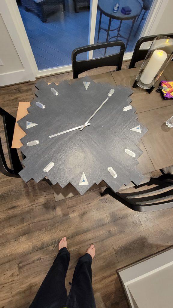 Clock face with silver hour markers, blue glass accents, and hands installed