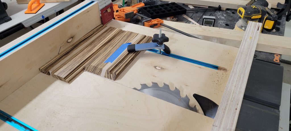 Glued-up Zebrawood and maple stock being cut into box parts on the table saw