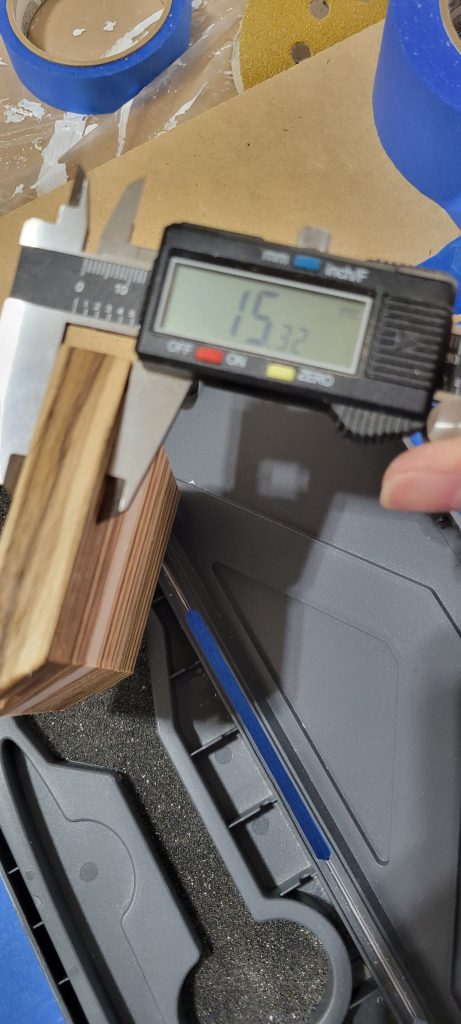 Digital calipers checking a Zebrawood and maple box part before assembly