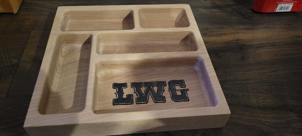 Finished monogrammed wooden catch-all tray shown from an angle with pocket depth visible