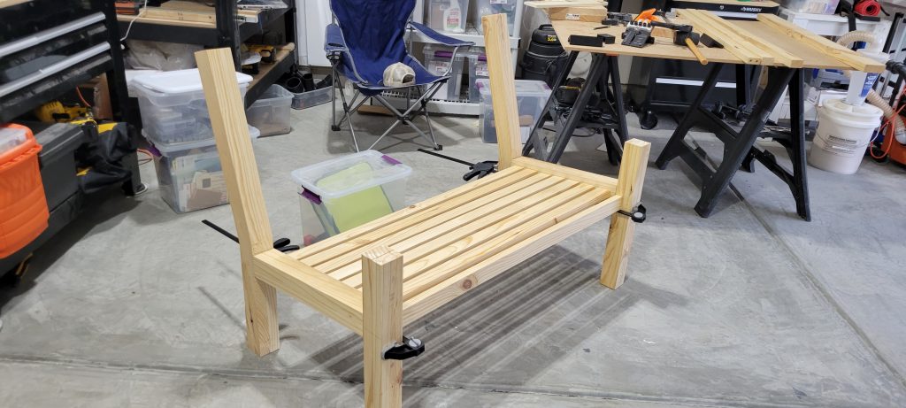 Pine bench frame and legs clamped during early assembly