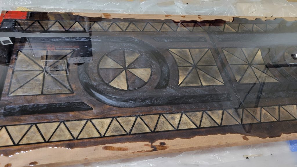 Entry table top covered in clear resin over the walnut and birdseye maple inlay pattern