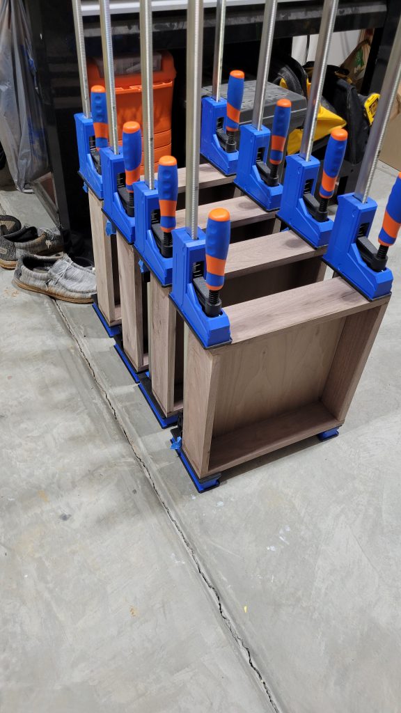 Walnut drawer fronts clamped while the rebuilt fronts cure during assembly