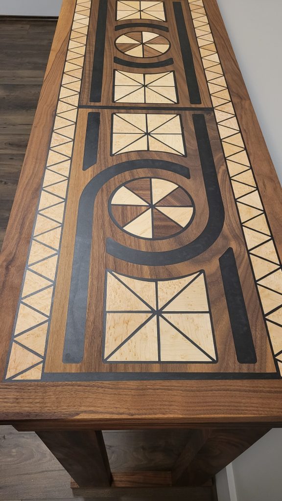 Finished entry table top detail with walnut, birdseye maple inlays, and black epoxy borders