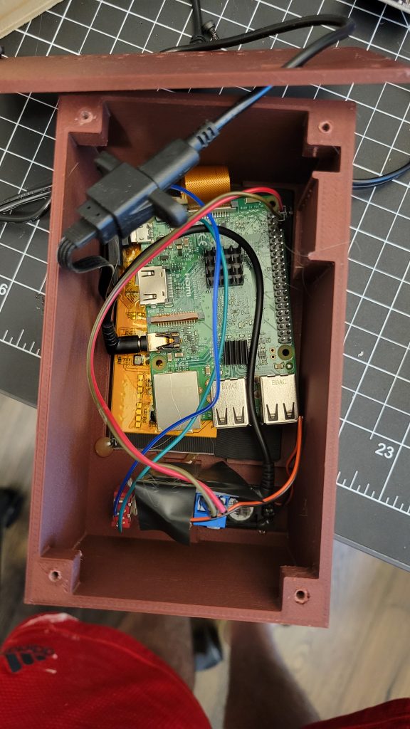 Inside of the printed mini TV case showing the Raspberry Pi, wiring, and screen assembly