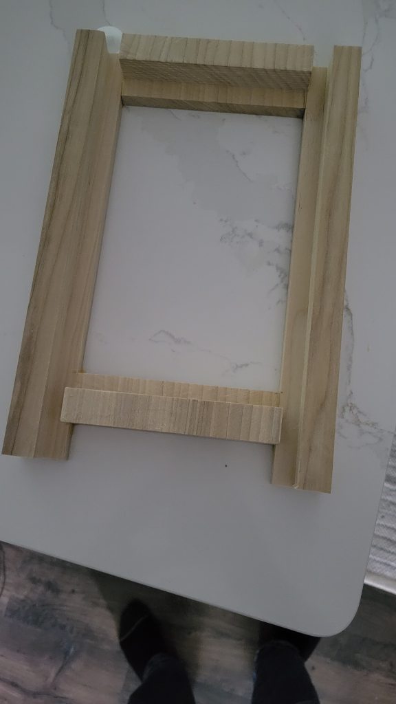 Raw wood frame assembly for the Magic Mirror daily dashboard before electronics were installed