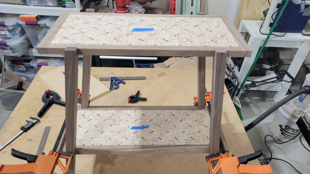 Patterned plywood panels test-fit in a side table frame after flattening.