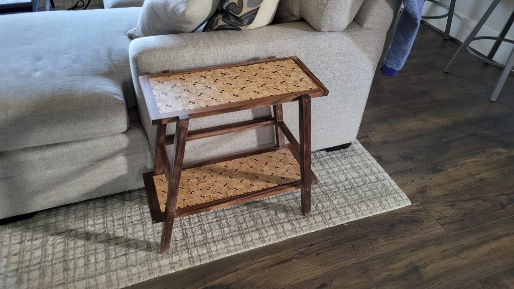 Finished side table showing the patterned plywood top, lower shelf, and walnut frame.