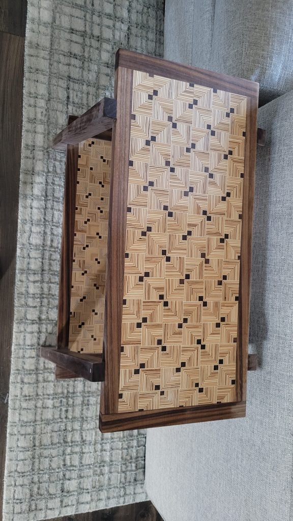 Close-up of the finished patterned plywood top with walnut accents.