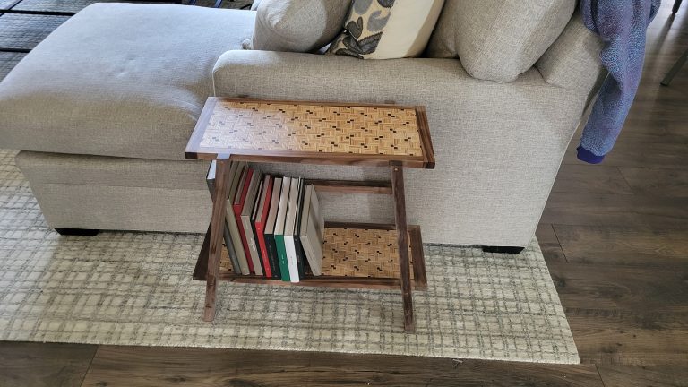 Finished patterned plywood side table with walnut frame in the room.