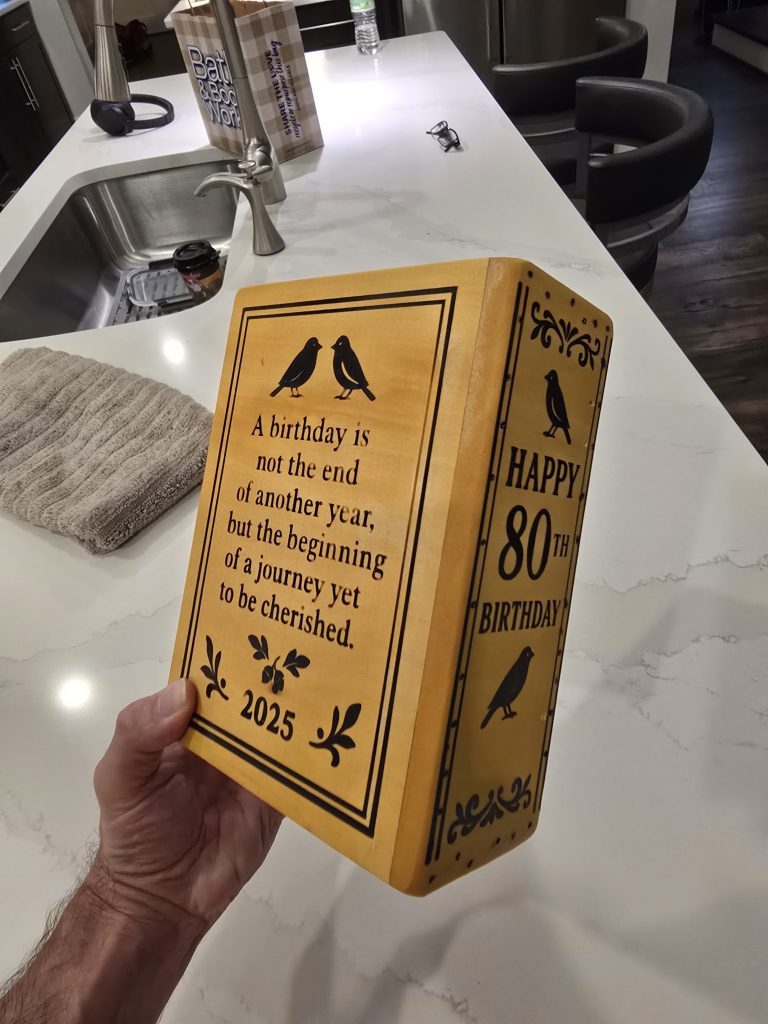 Finished book box showing the engraved birthday quote panel, Happy 80th Birthday spine, and 2025 detail.