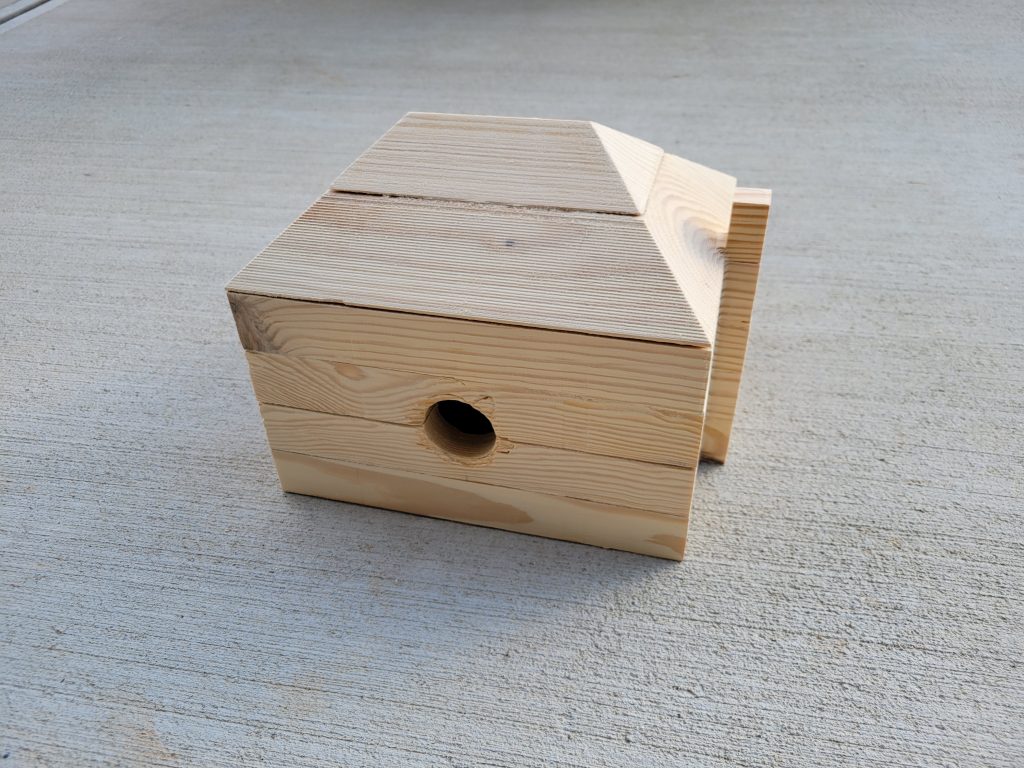 Unpainted layered wooden birdhouse body before finish work