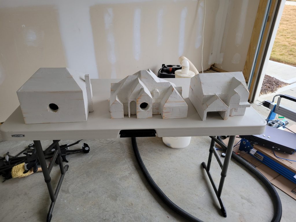 Primed custom birdhouses in the workshop before paint and detail work