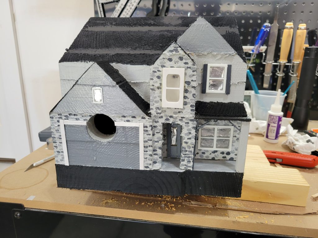 Finished CNC-carved birdhouse with a solar LED window