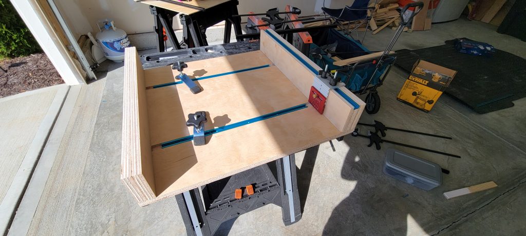 Completed crosscut sled with fences, blue T-track, hold-downs, and stop block.