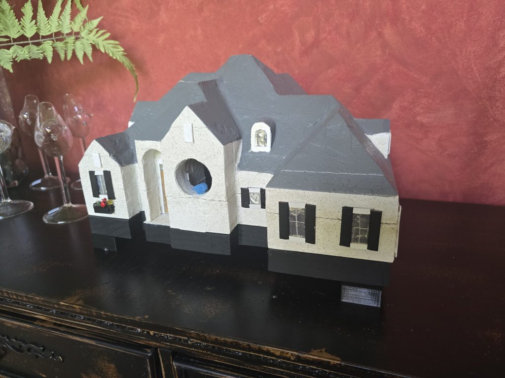 Close view of finished custom birdhouse roofline and hand-painted details