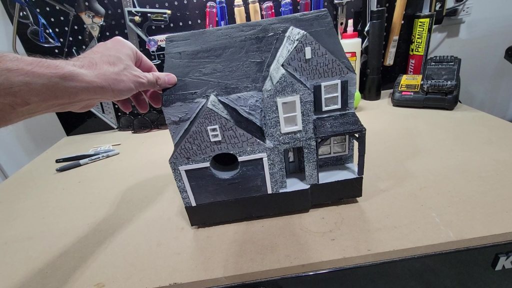 Still image of painting and trim work on the birdhouse
